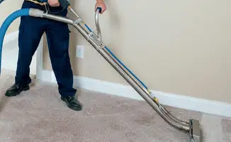 Professional operating a liquid removal machine on a carpeted floor in Wichita, KS